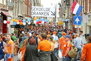 King's day amsterdam street full of people in orange celebrating
